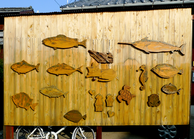 街角の魚のレリーフを貼ったユニークな塀
