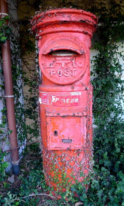 植物に浸食された郵便ポスト